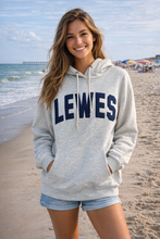 Load image into Gallery viewer, Woman wearing a gray hoodie with 'LEWES' on it at the beach.