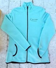Load image into Gallery viewer, Aqua blue full-zip fleece jacket featuring 'Lewes Delaware' text, black zipper, black trim on pockets, cuffs, and hem, laid flat on a distressed white wooden surface.