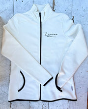 Load image into Gallery viewer, Cream full-zip fleece jacket featuring 'Lewes Delaware' text, black zipper, black trim on pockets, cuffs, and hem, laid flat on a distressed white wooden surface.