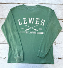 Load image into Gallery viewer, Flat lay of a washed palm Comfort Colors long sleeve t-shirt with "LEWES SINCE 1631 DELAWARE" text and crossed white oars graphic on a distressed white wooden background.