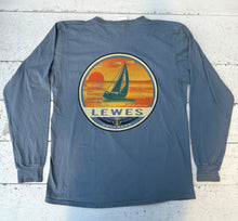 Load image into Gallery viewer, Back view of a Baltic long-sleeve t-shirt featuring a large circular graphic of a sailboat against an orange and yellow sunset with "LEWES DELAWARE" text and "Established 1631" with an anchor symbol.