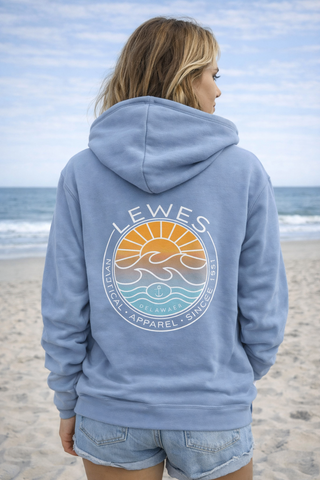 Woman wearing a blue hoodie with a logo and text on the beach