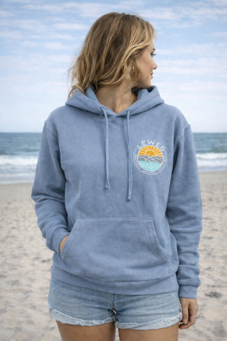 Woman wearing a blue hoodie with a graphic design on a beach