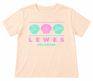 Lewes Delaware Shell Tee in Butter yellow with three scallop shells in aqua and pink between two lines, above LEWES and Delaware