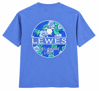 Lewes Sea Turtle Tee in Peri, back view, with a sea turtle over blue and green hibiscus flowers in a Lewes Delaware 1631 circle