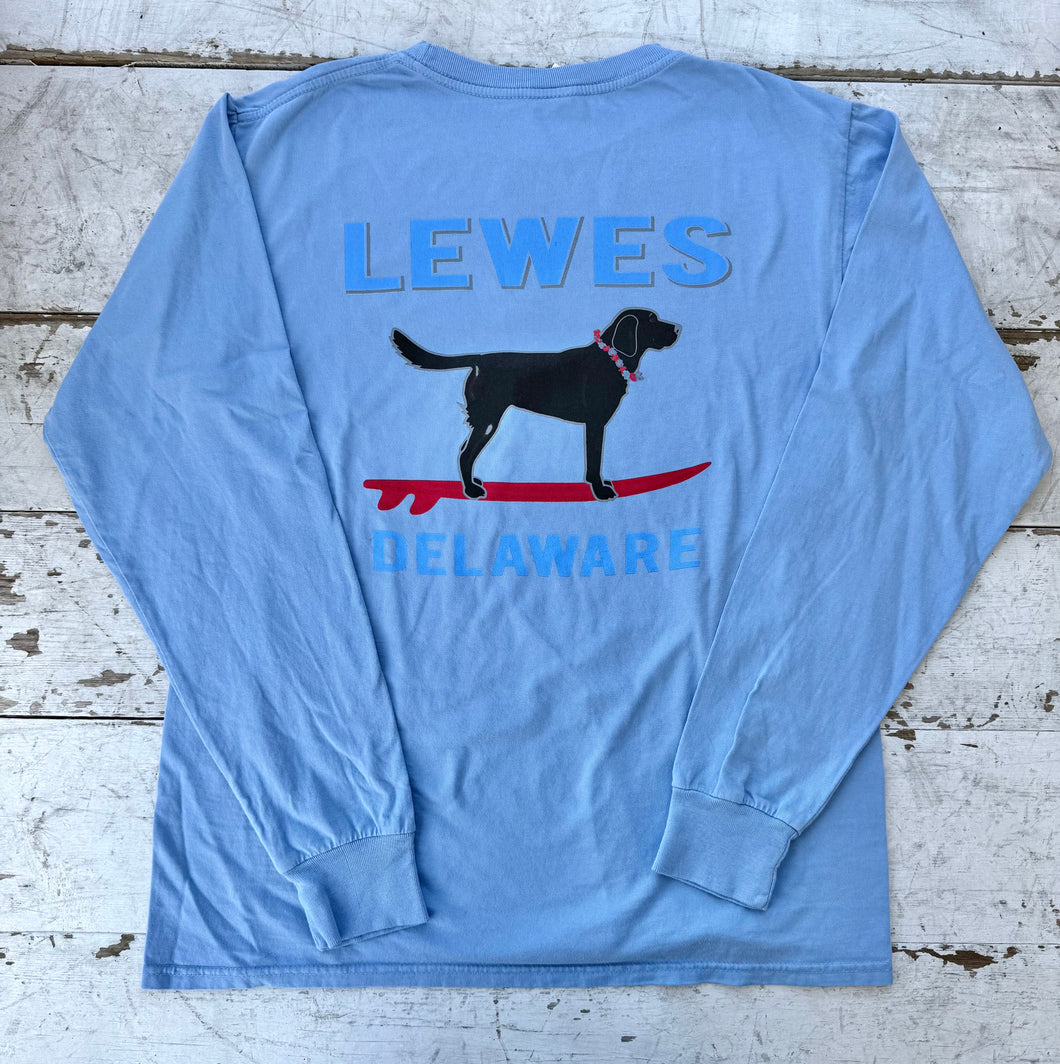 Cornflower blue long sleeve t-shirt with 'LEWES' and 'DELAWARE' text, featuring a black Labrador dog on a red surfboard, facing right.