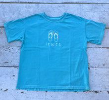 Load image into Gallery viewer, Aqua blue short-sleeve t-shirt with a white outline graphic of two flip-flops above the word &quot;Lewes&quot;, laid flat on a weathered white wooden surface.
