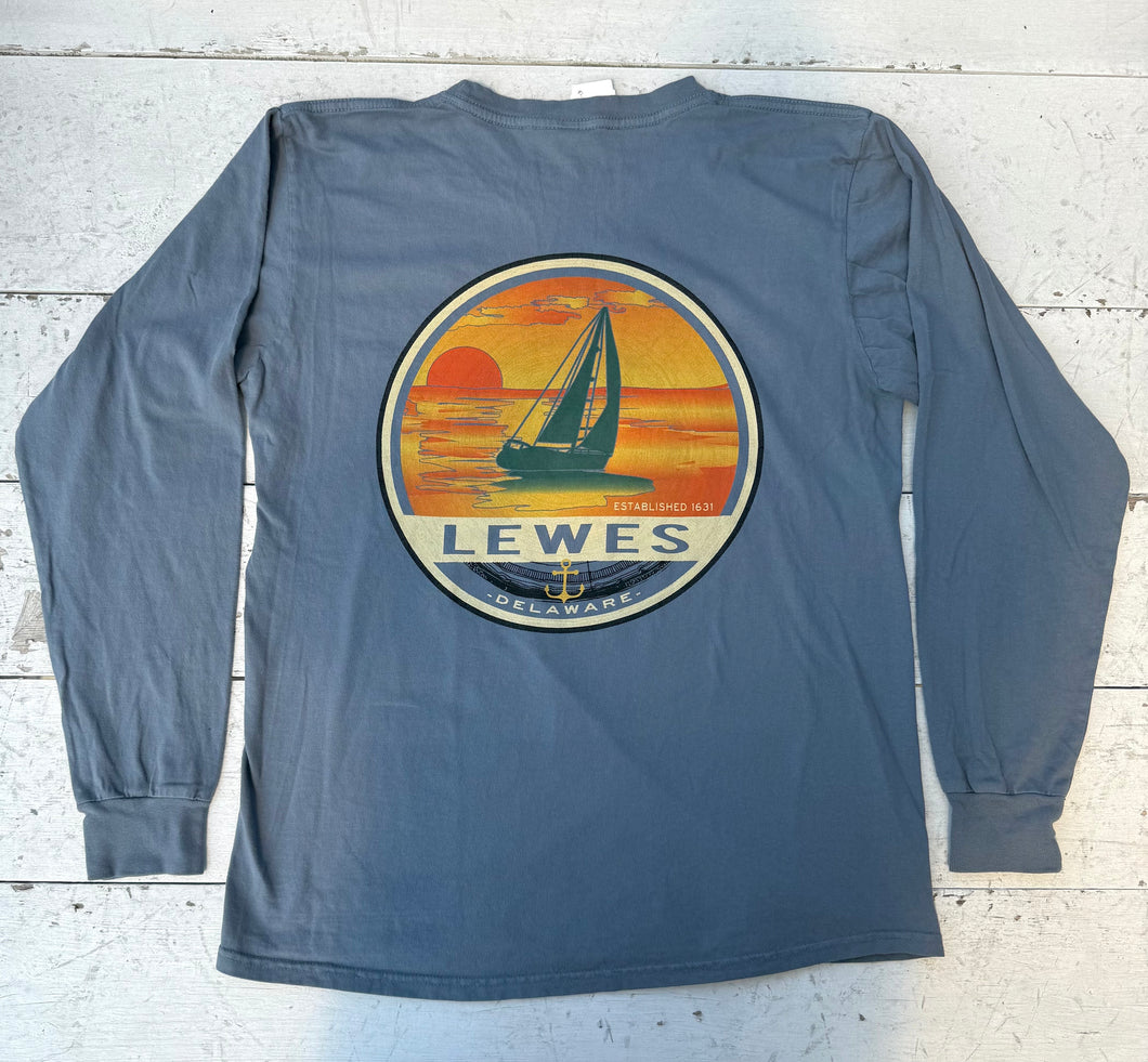 Back view of a Baltic long-sleeve t-shirt featuring a large circular graphic of a sailboat against an orange and yellow sunset with 